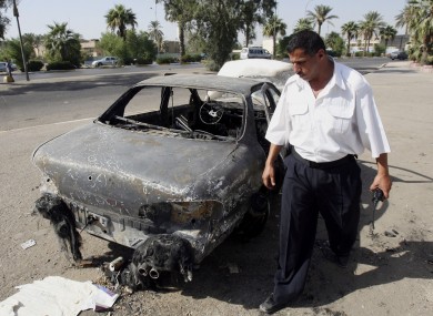 An Iraqi traffic policeman inspects a car destroyed by a Blackwater security detail in al-Nisoor Square in Baghdad in 2007.