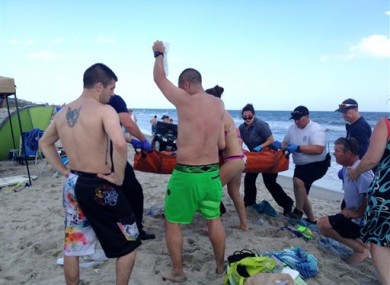 File photo of emergency responders assisting a teenager at the scene of a shark attack in Oak Island, N.C.