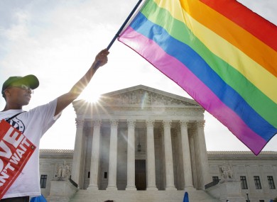 Carlos McKnight of Washington, waves a flag in support of gay marriage outside of the Supreme Court in Washington