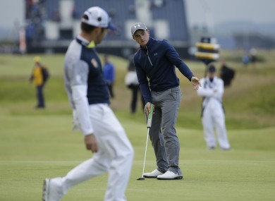 Dunne follows his putt on the 16th green as Ooosthuizen looks on.
