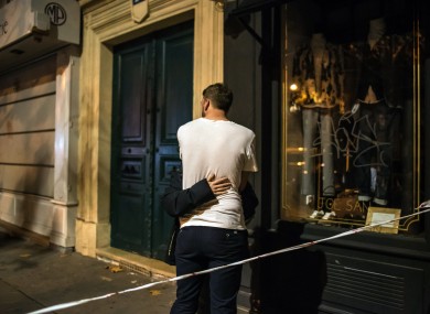 A couple conforts each other outside the Bataclan concert hall after a shooting in Paris.