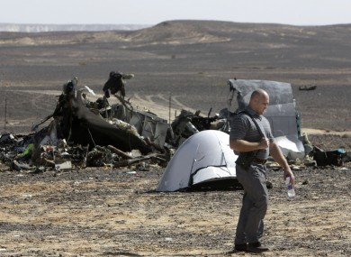 A Russian investigator walks near wreckage a day after a passenger jet bound for St Petersburg crashed in Hassana, Egypt.