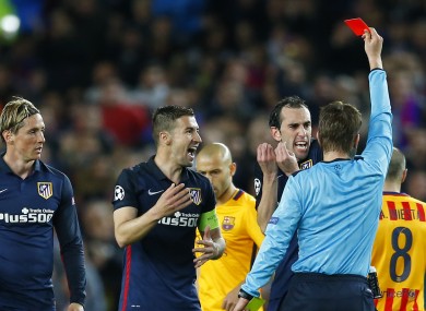 Referee Felix Brych turns away after showing a red card to Atletico's Fernando Torres.