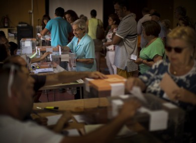 A woman casts her vote for the national elections in Barcelona, Spain.