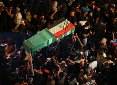 Mourners carry the Iraqi flag-draped coffin of a bomb victim during a funeral procession in the bustling commercial district of Karada, Baghdad