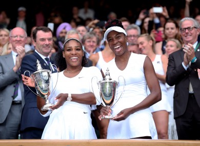 Serena and Venus Williams celebrate victory in the women's doubles on day twelve of the Wimbledon Championships.