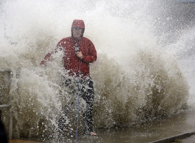 A news reporter doing a stand up near a sea wall in Cedar Key, Florida, is covered by an unexpected wave.