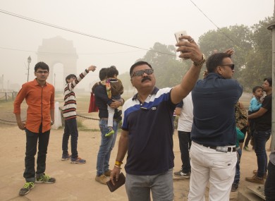 Indian tourists take selfies next to the war memorial India Gate in New Delhi earlier this month.
