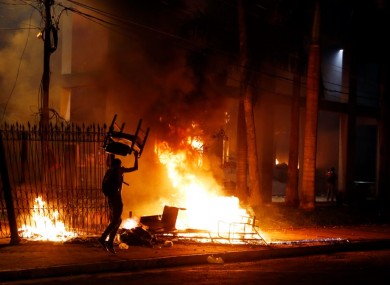 A protester carries a chair to a fire outside the congress building