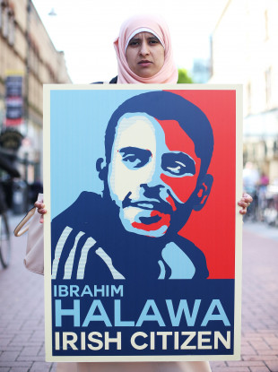 Somaia Halawa, sister of Ibrahim, holds a poster bearing her brother's face. ,