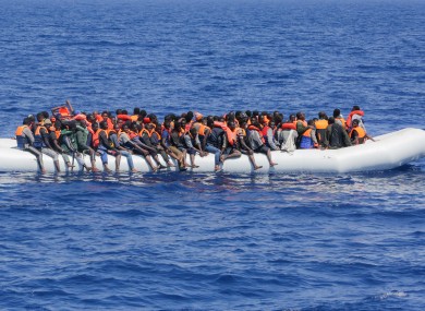 Refugees and migrants are seen floating in an overcrowded rubber boat.