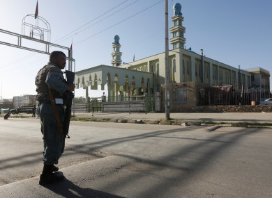 An Afghan policeman stands guard outside a mosque where a suicide bomber detonated a bomb, in Kabul, Afghanistan last week.