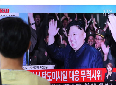 A man in Seoul watches a TV programme showing an image of North Korean leader Kim Jong-un
