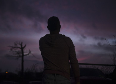 man looks at the horizon early in the morning after the passing of Hurricane Maria.