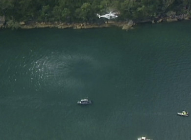 A search and rescue helicopter flies above search boats in Hawkesbury River, New South Wales, Australia