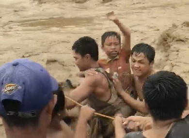 Villagers cross raging flood waters in Lanao del Norte, Zamboanga Peninsula, southern Philippines.