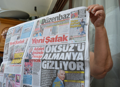 A woman holds a copy of Turkish pro-government daily newspaper