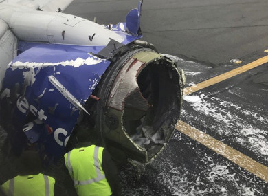The engine on a Southwest Airlines plane is inspected as it sits on the runway at the Philadelphia International Airport after it made an emergency landing in Philadelphia,