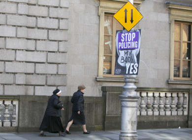 A nun walks past a Yes poster in Dublin earlier this month.