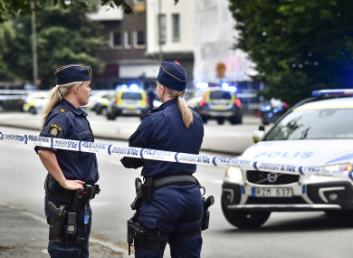 Police stand next to a cordon after five people were shot and injured on an open street in central Malmo.