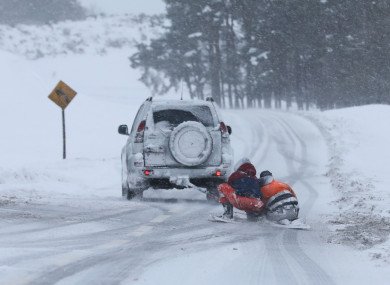 Two people on a makeshift snowboard are towed behind a jeep on the R413 road through the Curragh in County Kildare during Storm Emma earlier this year.