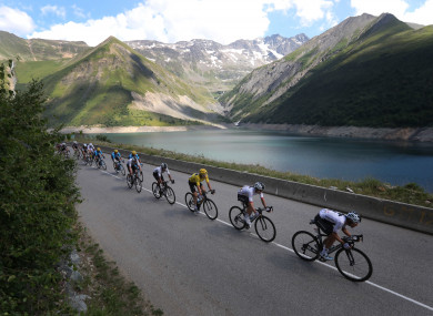 The pack with Britain's Geraint Thomas, wearing the overall leader's yellow jersey speeds down Croix de Fer pass.