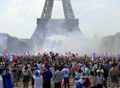 Supporters of the French soccer team react on the Champ de Mars next to the Eiffel Tower in Paris.