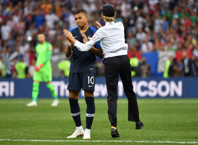 A member of Pussy Riot high-fives French star Kylian Mbappé.