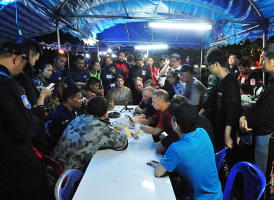 A rescuer briefs the press about the condition of the 12 teenagers and their football coach.