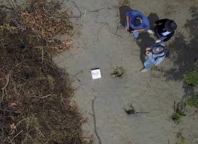 In this undated photo provided by the Veracruz State Prosecutor's Office shows workers at the site of clandestine burial pits.