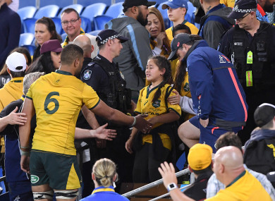 Lukhan Tui of the Wallabies (left) assists a family member after an altercation between Tui and a spectator.