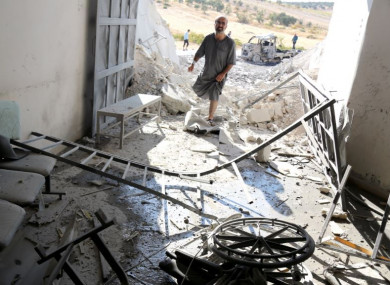 A Syrian man inspects the wreckage at a site after Syrian government airstrikes, which targeted the civilian hospital in Hass, rural Idlib, in September 2018.