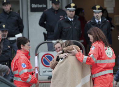 Relatives and friends comfort each others outside the morgue in Corinaldo.