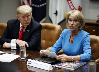 Trump listens as Secretary of Education Betsy DeVos speaks during a roundtable discussion on the Federal Commission on School Safety report