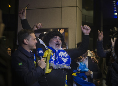 A Boca Juniors fan dressed as Maradona cheers outside the team's hotel in Madrid.