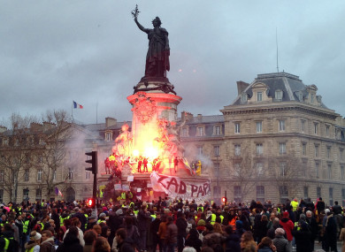 French anti-government protestors set alight a flare on the statue of Marianne, symbol of the Republic, in Paris, 8 December.