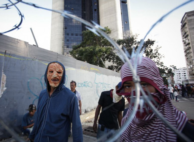 Masked protesters seen behind a fence during a mass protest against Venezuelan President Nicolás Maduro in Caracas this week.
