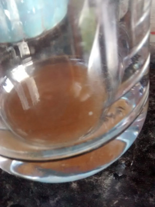 Discoloured sediment at the bottom of a glass