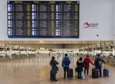 Passengers stand in a deserted departure hall at Brussels Airport in Zaventem, today.