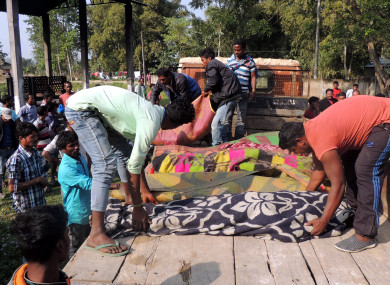 Locals arrange bodies of victims who died of consuming liquor.