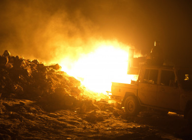 SDF fighters fire on IS militant positions in Baghouz.