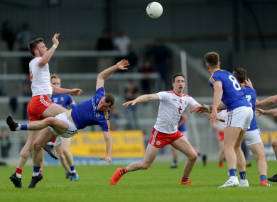 Tyrone's Brian Kennedy and David McGivney of Longford contest a high ball .