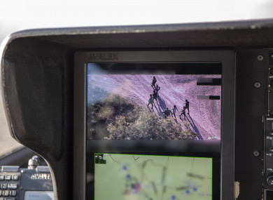 US Border Patrol agents watching Central American migrants who crossed the Rio Grande River from Mexico illegally on the camera of a search helicopter.