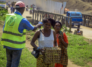 People crossing the Uganda-Congo border have their temperature checked for symptoms.