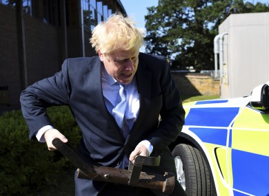 Boris Johnson holds a battering ram during campaigning.