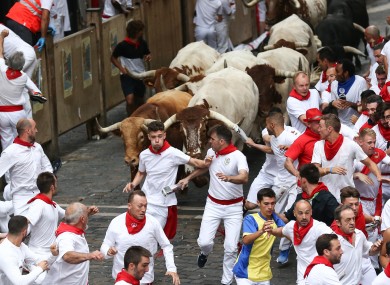 Bulls un down a street during the traditional San Fermin bull run in Pamplona.
