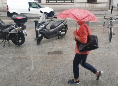 After weeks of good weather, today's sudden downpour sent Dublin residents running for cover. Pictured are pedestrians with umbrellas braving the wet weather.