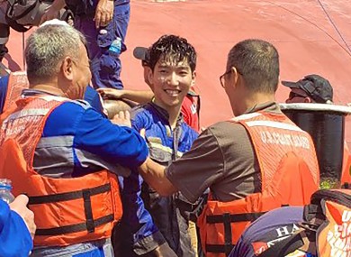 A crew member of the cargo ship Golden Ray as he is helped off the capsized ship.