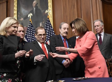 House Speaker Nancy Pelosi gives pens out after signing the resolution to transmit articles of impeachment against President Donald Trump to the Senate.