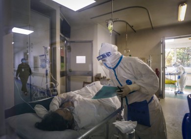 A medical worker checks on a patient at Jinyintan hospital in Wuhan.